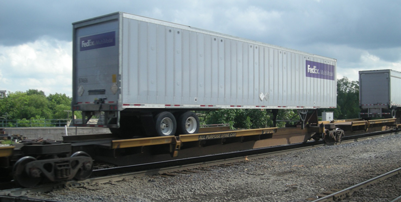 FIGURE 6. Traditional Trailer-on-Flatcar
This image shows a full-sized semi-trailer being carried on the top of a railway flatcar.
FIGURE 6. Traditional Trailer-on-Flatcar
This image shows a full-sized semi-trailer being carried on the top of a railway flatcar.